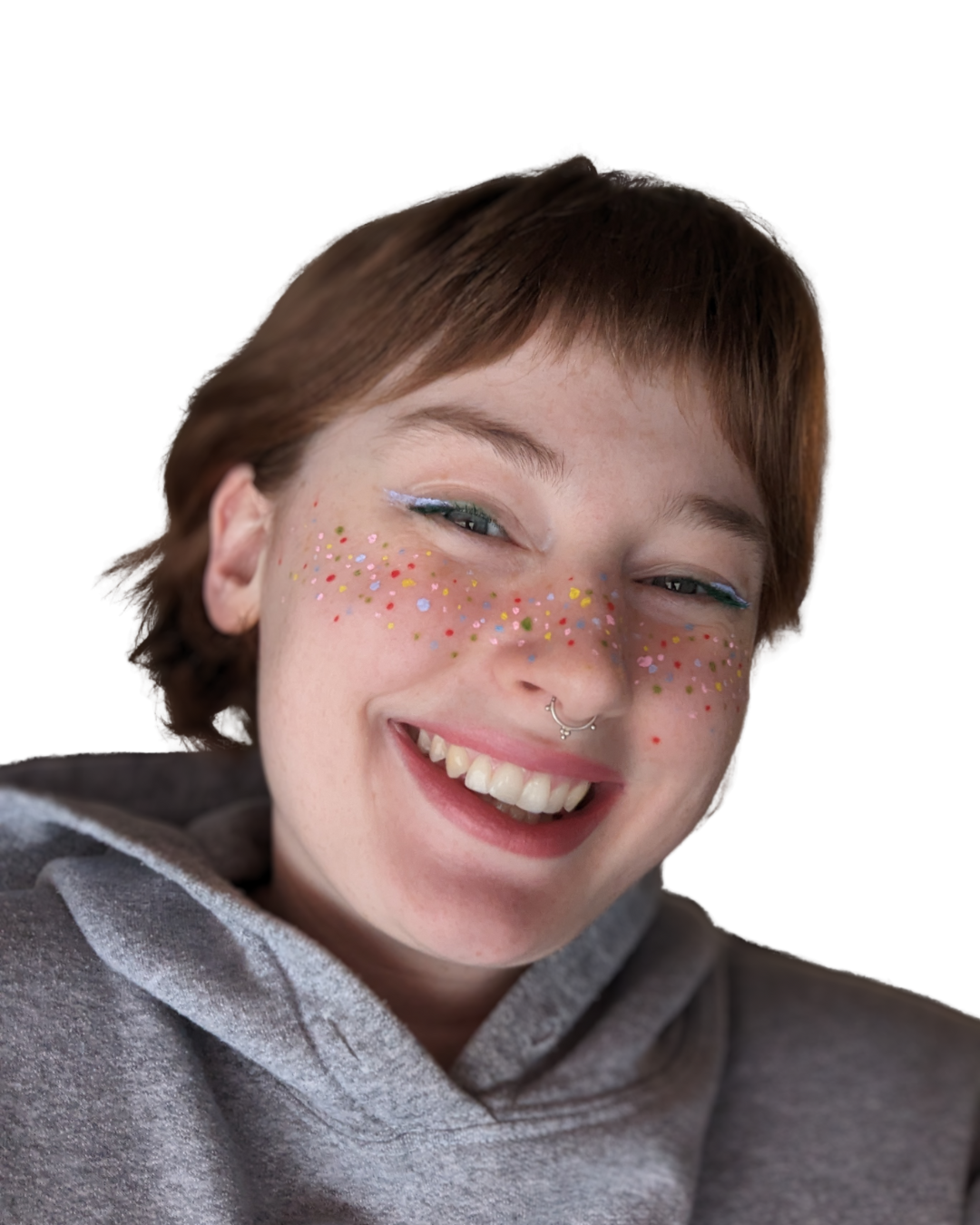 Portrait-style photo of Emma Gray, owner of kinky bestie wearing rainbow graphic makeup and smiling